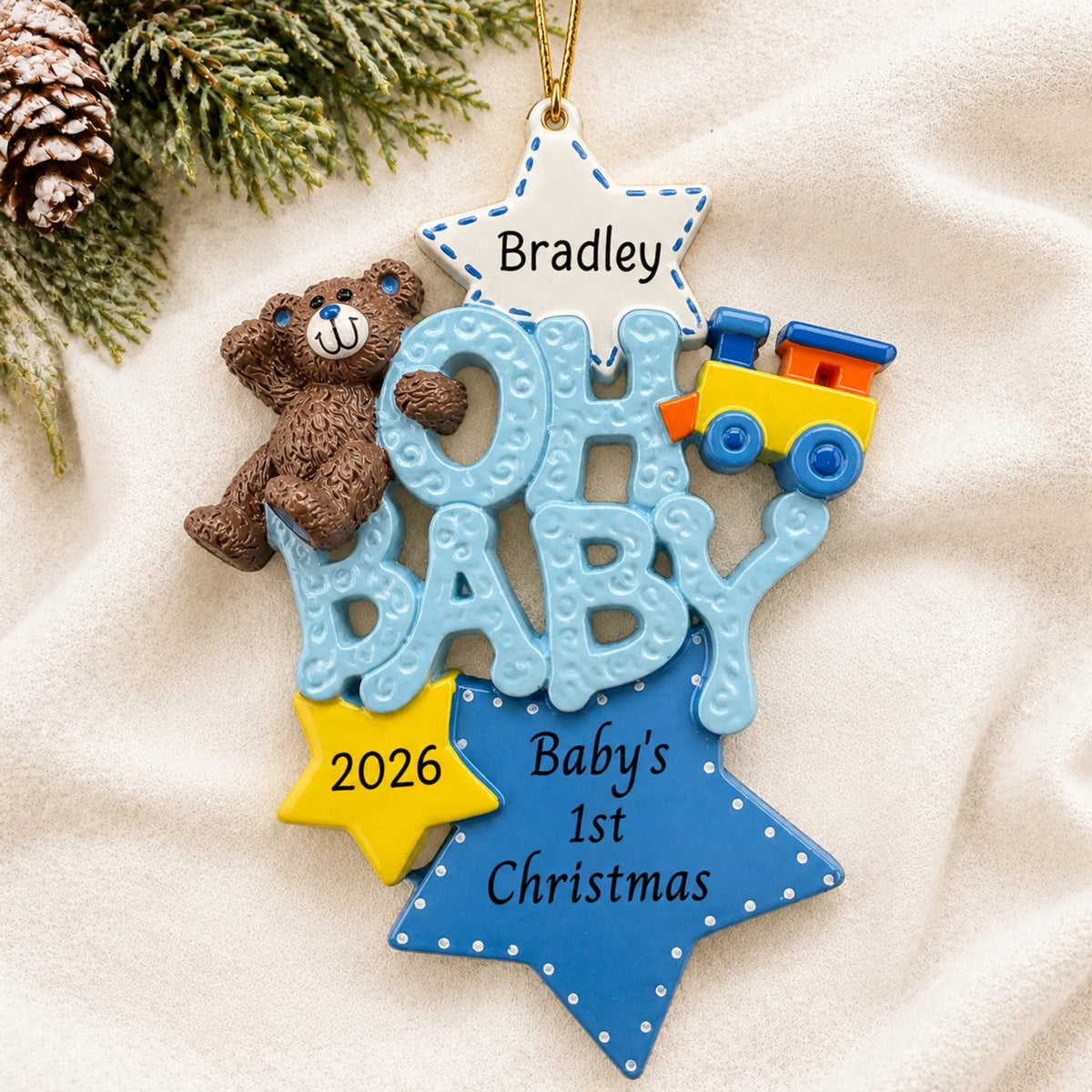 Personalized oh baby boy 1st christmas ornament laid on a soft white knit blanket