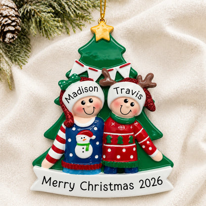Personalized ugly sweater holiday couple christmas ornament laid on a soft white knit blanket