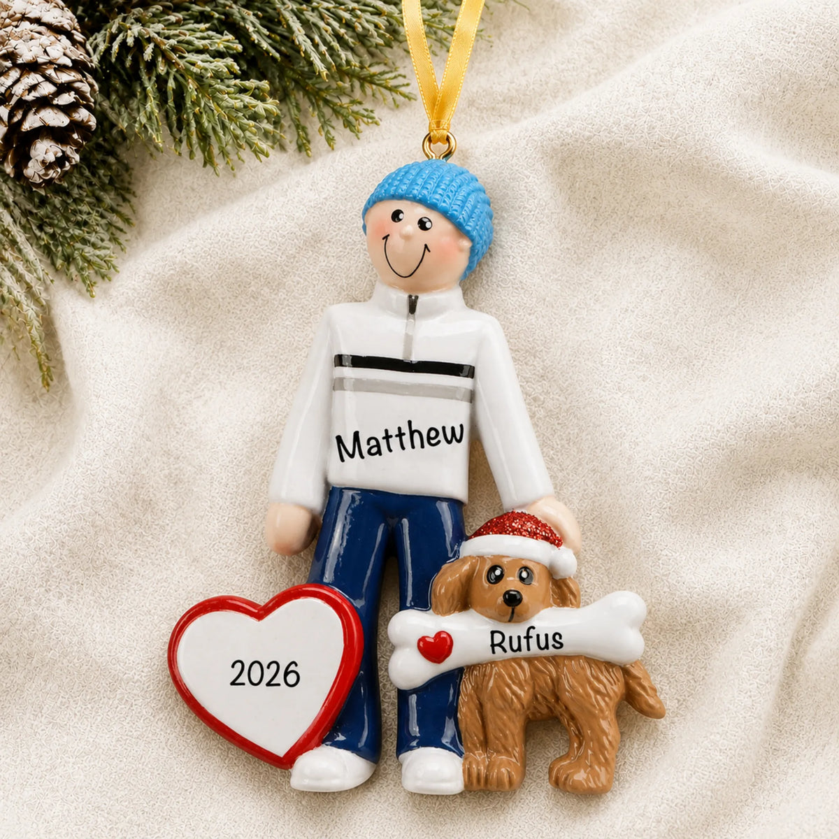 Personalized Man and Dog christmas ornament laid on a soft white knit blanket
