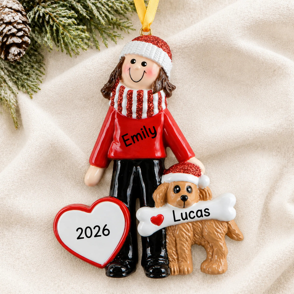 Personalized Woman and Dog christmas ornament laid on a soft white knit blanket
