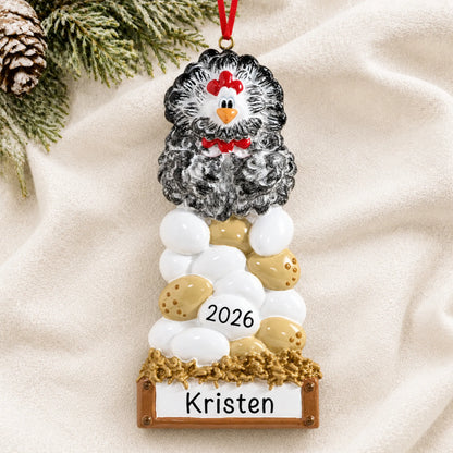 Personalized chicken laying eggs christmas ornament laid on a soft white knit blanket
