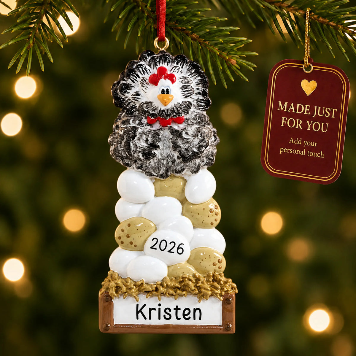 Chicken laying eggs christmas ornament hanging on a lit Christmas tree with a Made Just For You gift tag