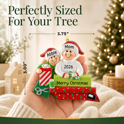 Size guide: the personalized single parent & child christmas ornament is 3.75 in wide by 3.00 in tall, shown in hand