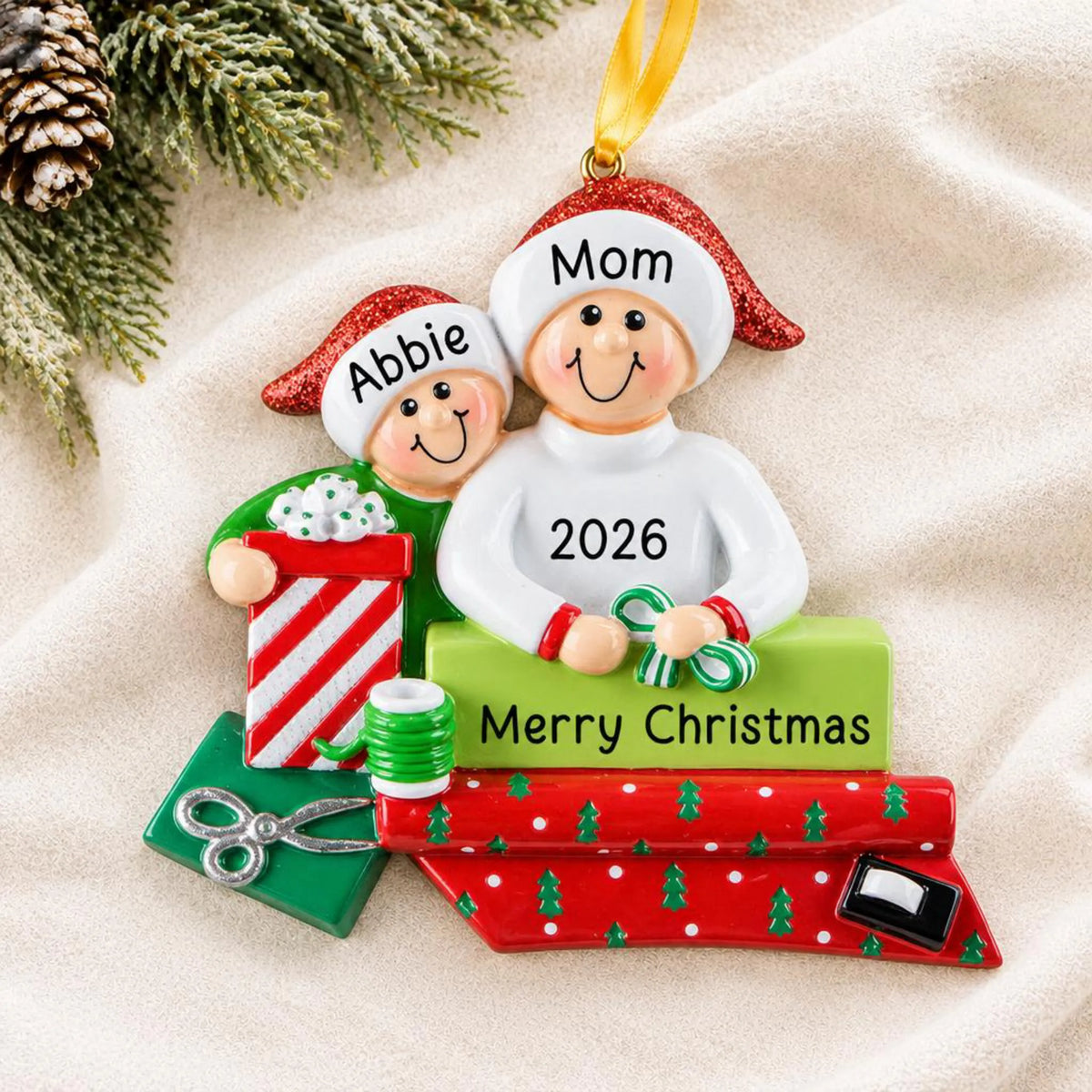 Personalized single parent & child christmas ornament laid on a soft white knit blanket