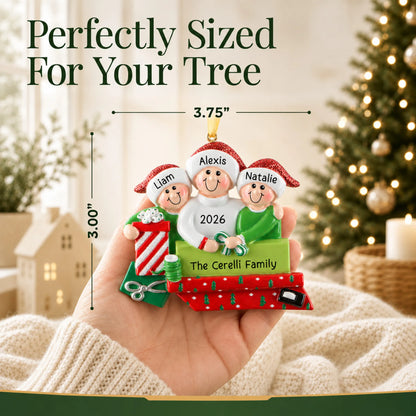 Size guide: the personalized single parent & 2 children christmas ornament is 3.75 in wide by 3.00 in tall, shown in hand