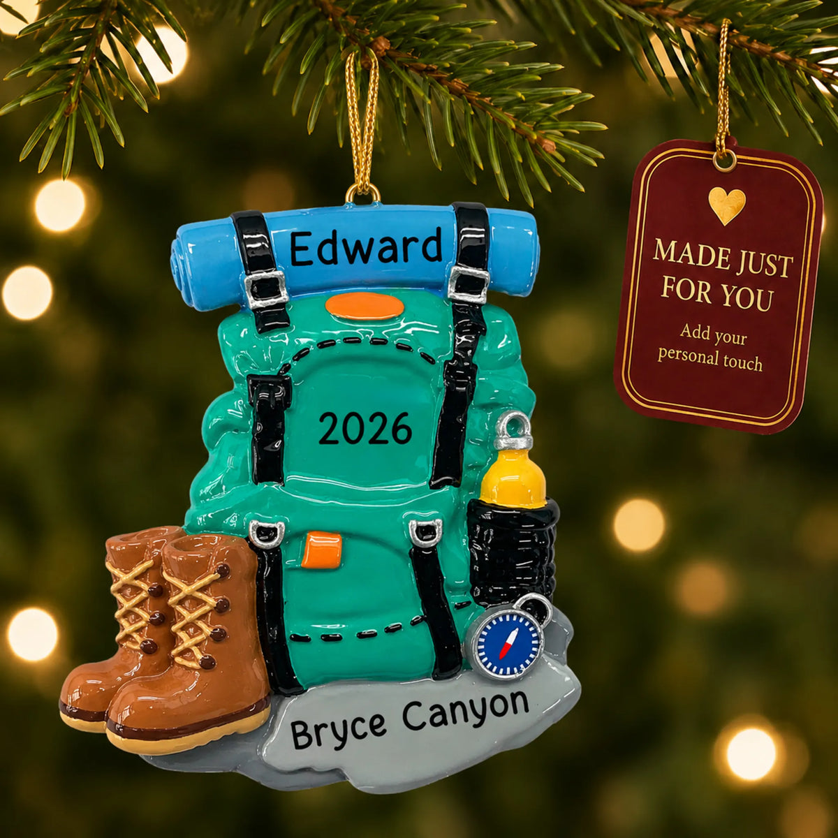 Hiking backpack christmas ornament hanging on a lit Christmas tree with a Made Just For You gift tag
