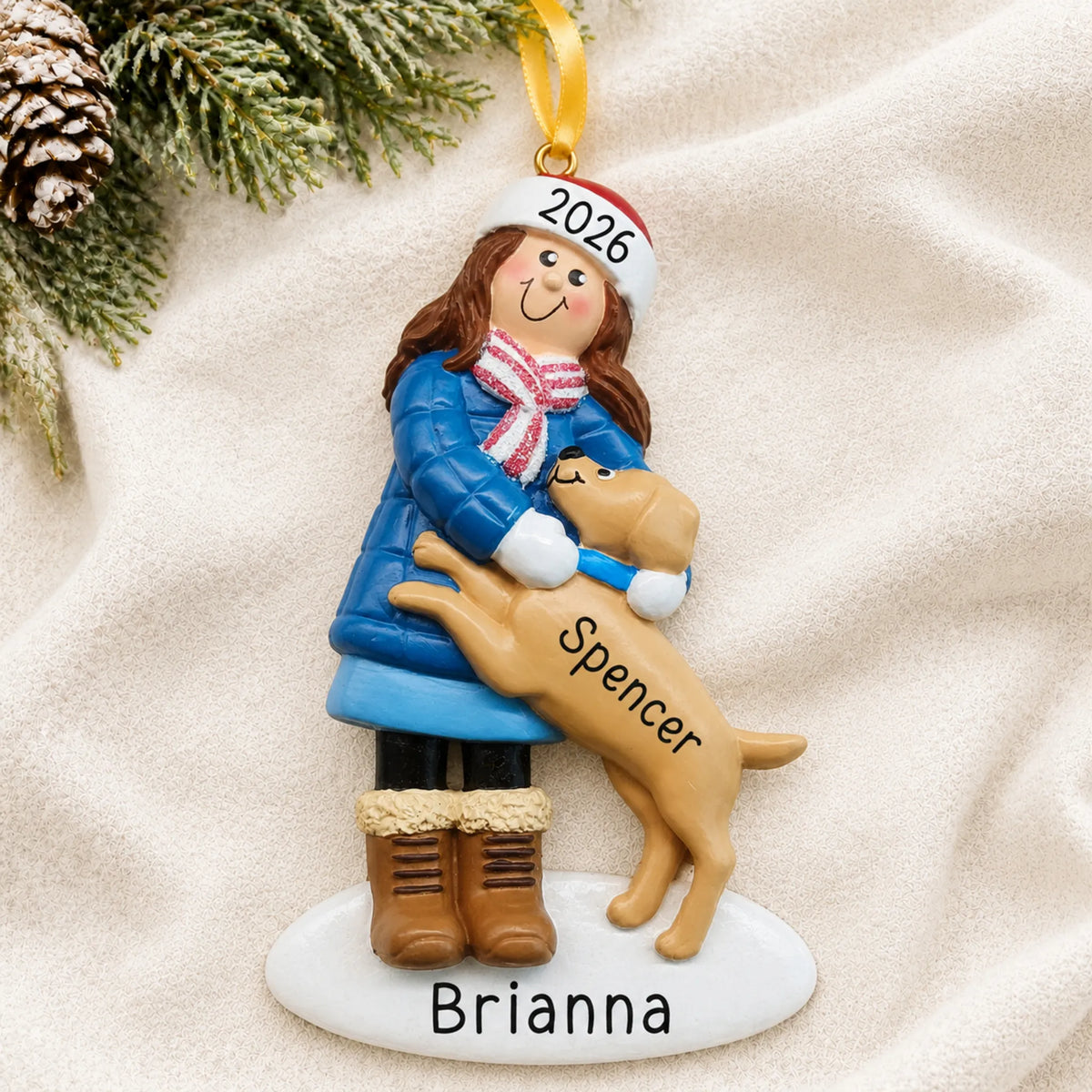 Personalized Girl With Brown Dog christmas ornament laid on a soft white knit blanket