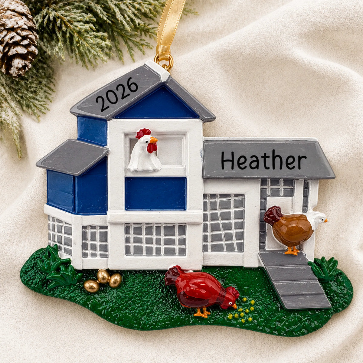 Personalized chicken coop christmas ornament laid on a soft white knit blanket