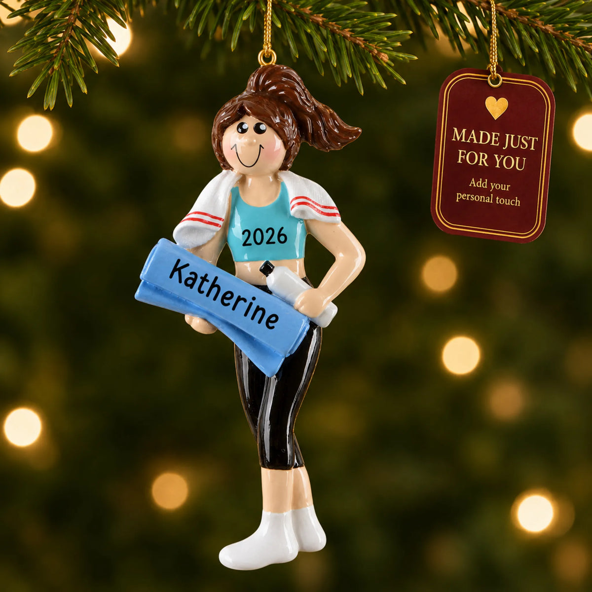 Yoga girl christmas ornament hanging on a lit Christmas tree with a Made Just For You gift tag