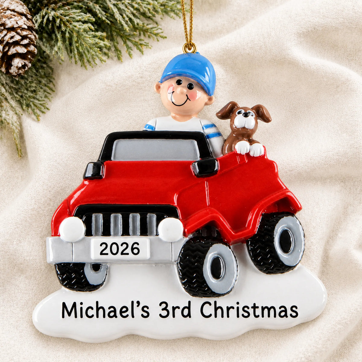 Personalized boys ride on electric car christmas ornament laid on a soft white knit blanket
