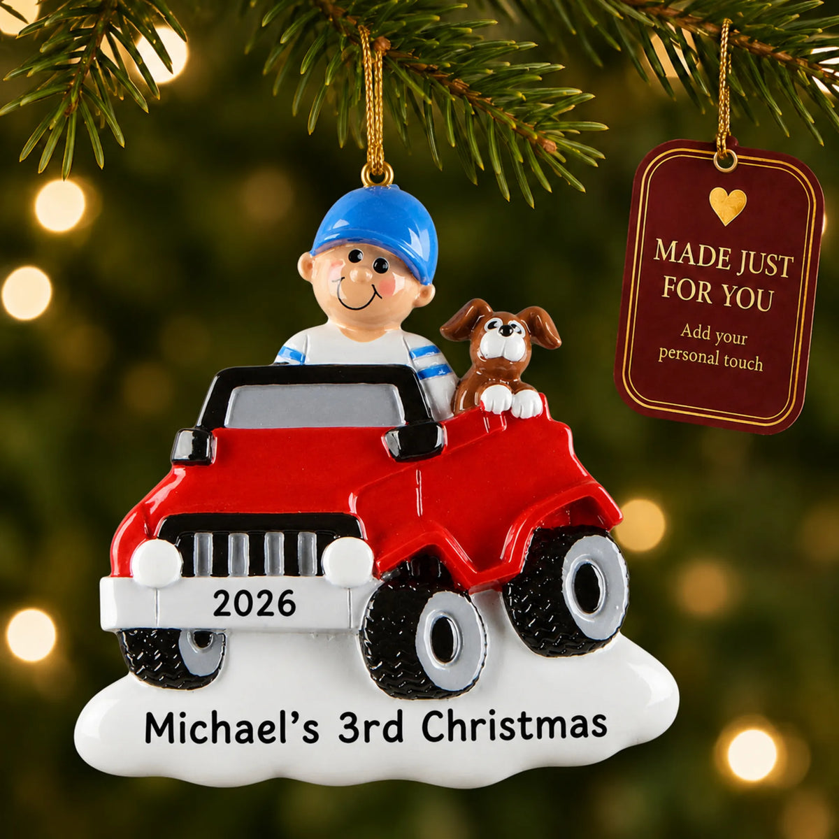 Boys ride on electric car christmas ornament hanging on a lit Christmas tree with a Made Just For You gift tag