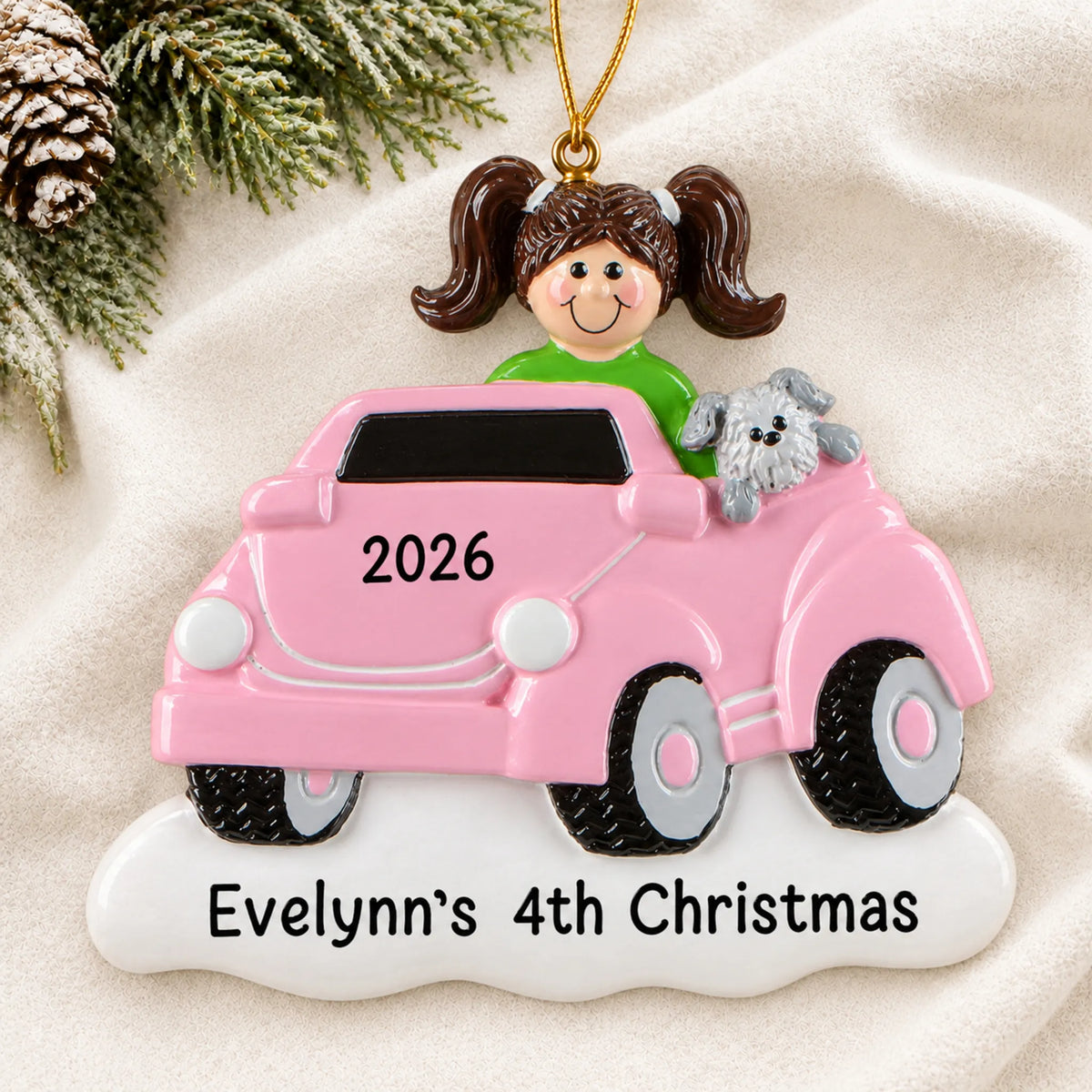 Personalized girls ride on electric car christmas ornament laid on a soft white knit blanket