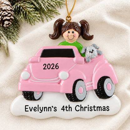 Personalized girls ride on electric car christmas ornament laid on a soft white knit blanket