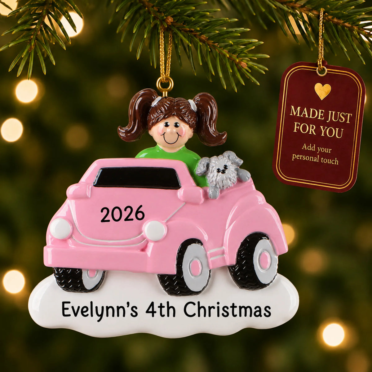 Girls ride on electric car christmas ornament hanging on a lit Christmas tree with a Made Just For You gift tag