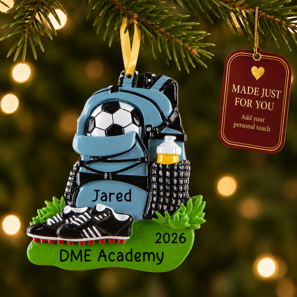 Soccer gear christmas ornament hanging on a lit Christmas tree with a Made Just For You gift tag