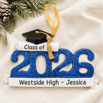 Front view of the personalized Class of 2026 blue graduation Christmas ornament with grad cap and school banner