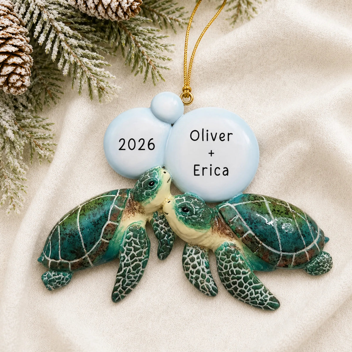 Personalized sea turtle couple christmas ornament laid on a soft white knit blanket