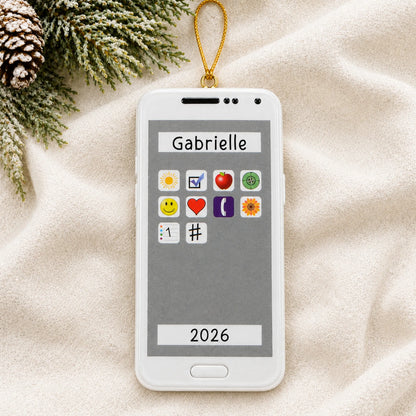 Personalized white smartphone christmas ornament laid on a soft white knit blanket