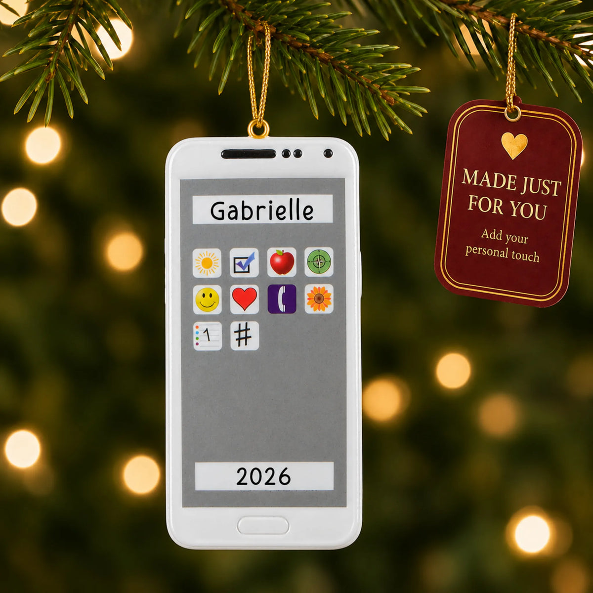 White smartphone christmas ornament hanging on a lit Christmas tree with a Made Just For You gift tag