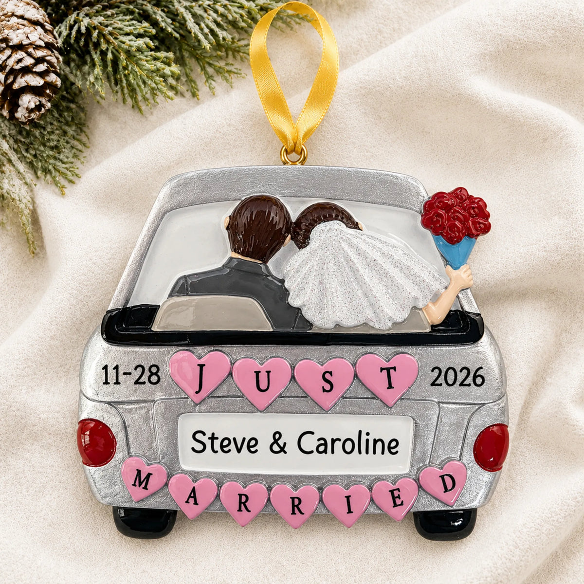 Personalized Just Married Car Silver christmas ornament laid on a soft white knit blanket