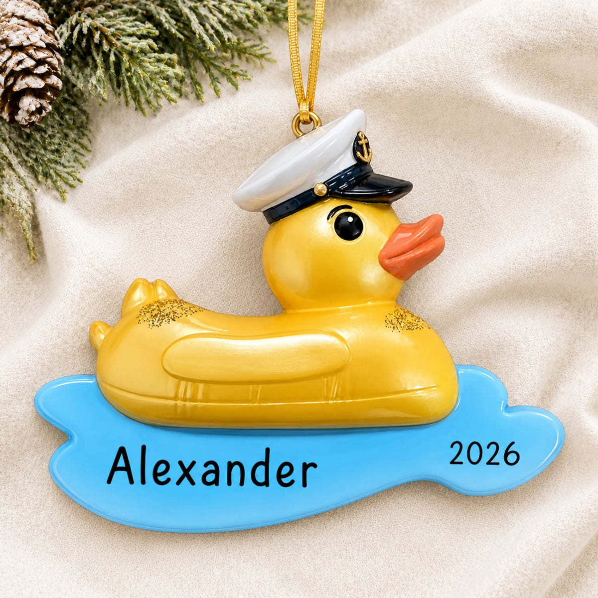 Personalized rubber ducky floatie christmas ornament laid on a soft white knit blanket