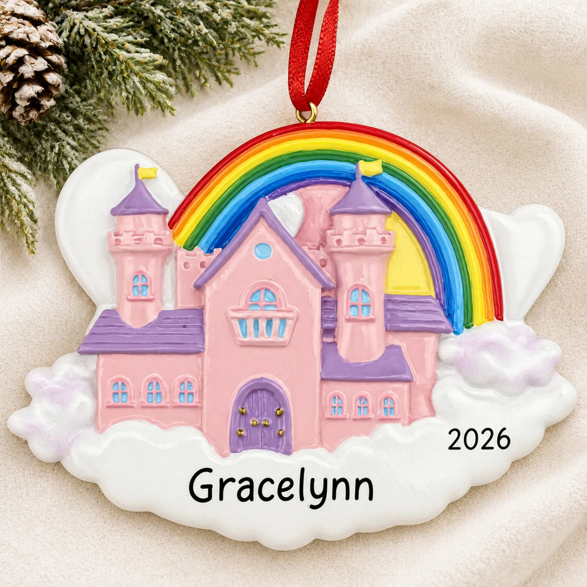 Personalized princess castle magical rainbow christmas ornament laid on a soft white knit blanket