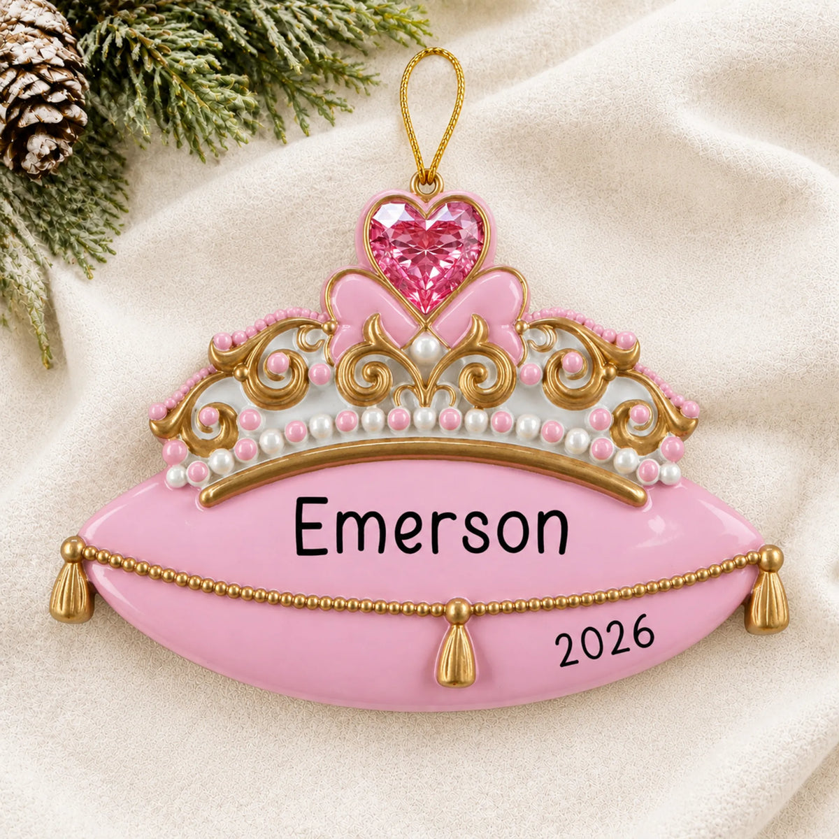 Personalized princess tiara christmas ornament laid on a soft white knit blanket