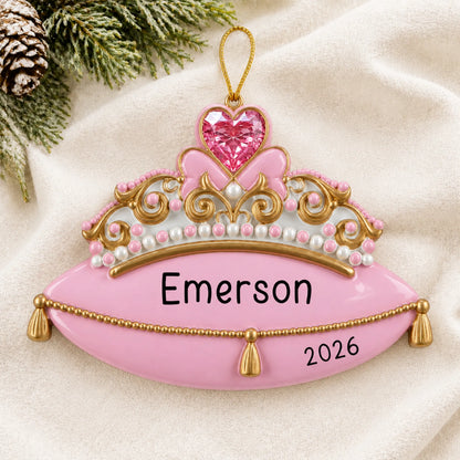 Personalized princess tiara christmas ornament laid on a soft white knit blanket