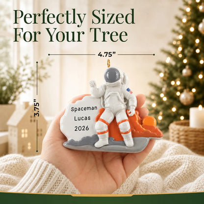 Size guide: the personalized astronaut christmas ornament is 4.75 in wide by 3.75 in tall, shown in hand