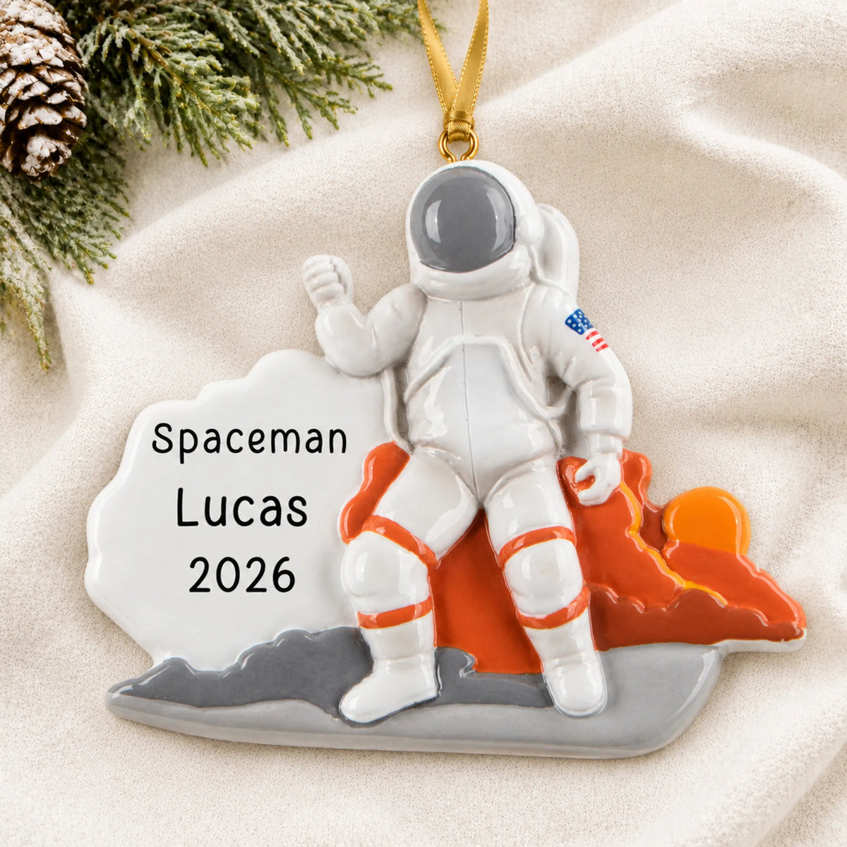 Personalized astronaut christmas ornament laid on a soft white knit blanket