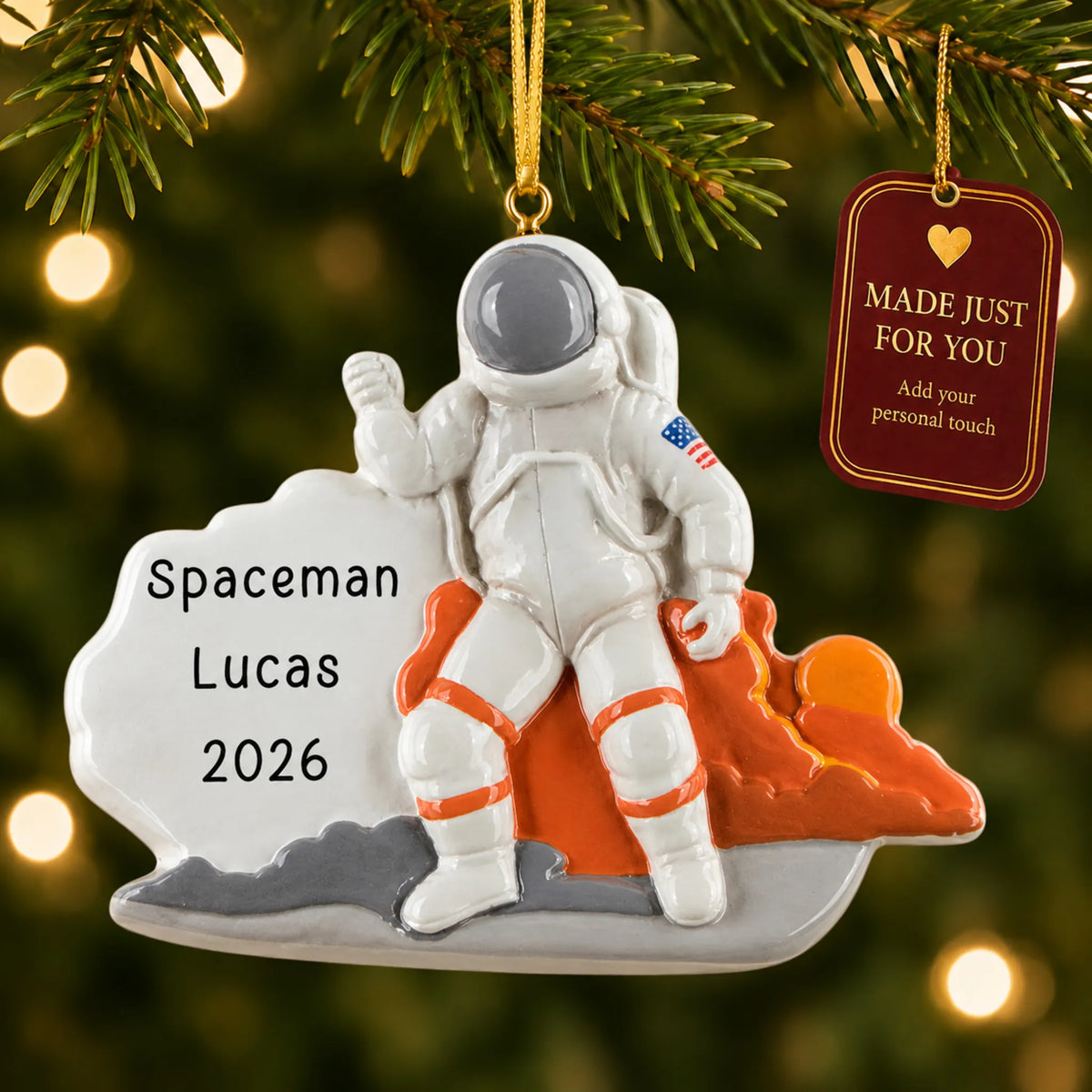 Astronaut christmas ornament hanging on a lit Christmas tree with a Made Just For You gift tag
