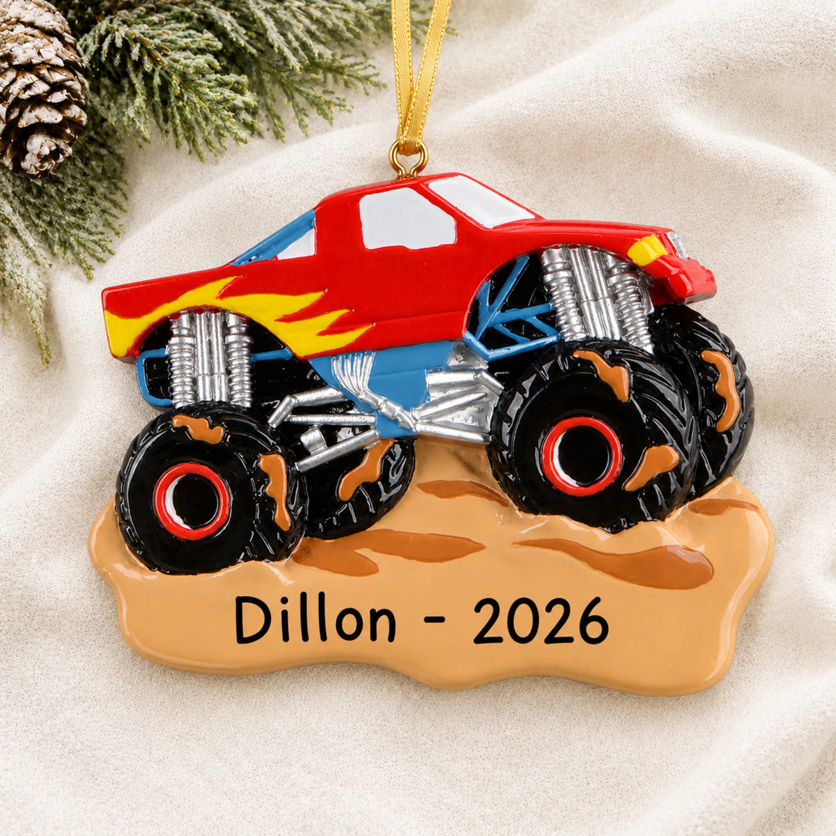 Personalized monster truck muddin christmas ornament laid on a soft white knit blanket