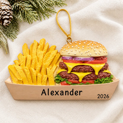 Personalized Burger & Fries christmas ornament laid on a soft white knit blanket