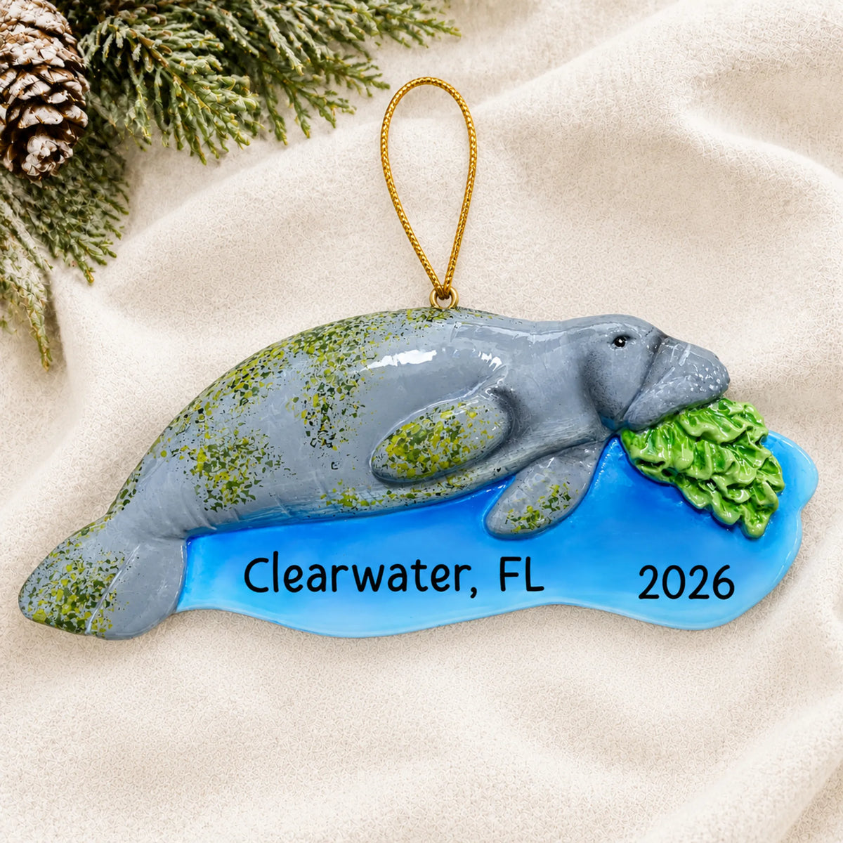 Personalized manatee christmas ornament laid on a soft white knit blanket