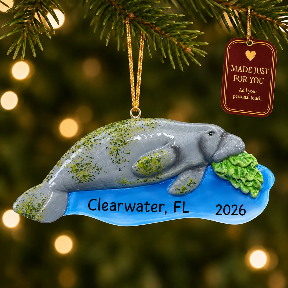 Manatee christmas ornament hanging on a lit Christmas tree with a Made Just For You gift tag