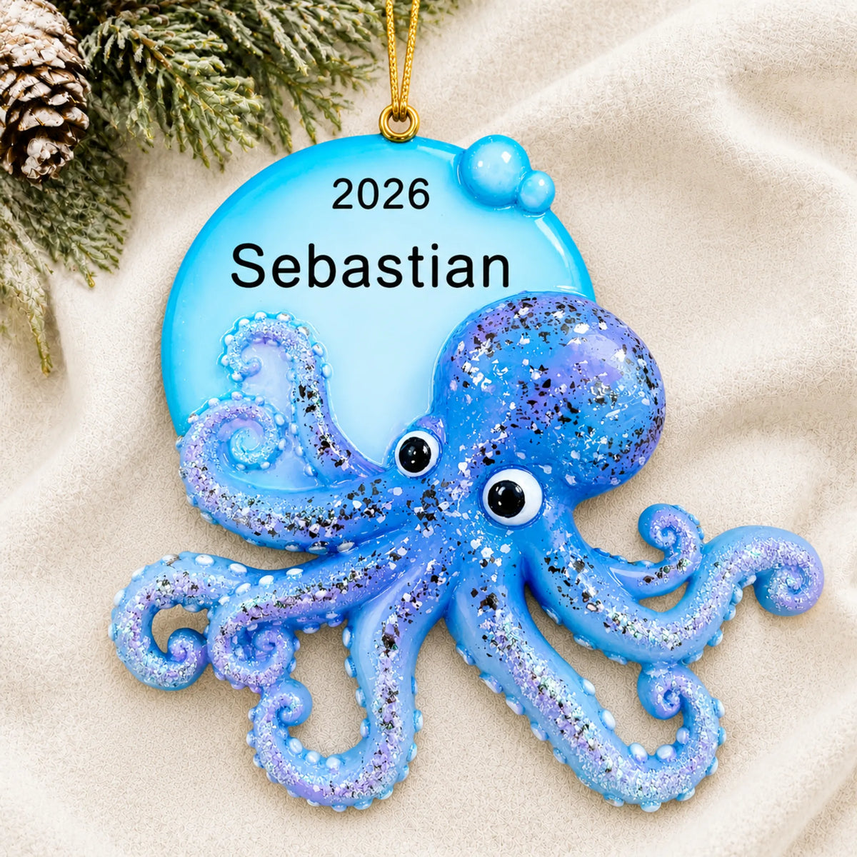 Personalized octopus christmas ornament laid on a soft white knit blanket