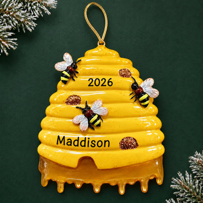 Personalized honey beehive christmas ornament on a dark green pine background