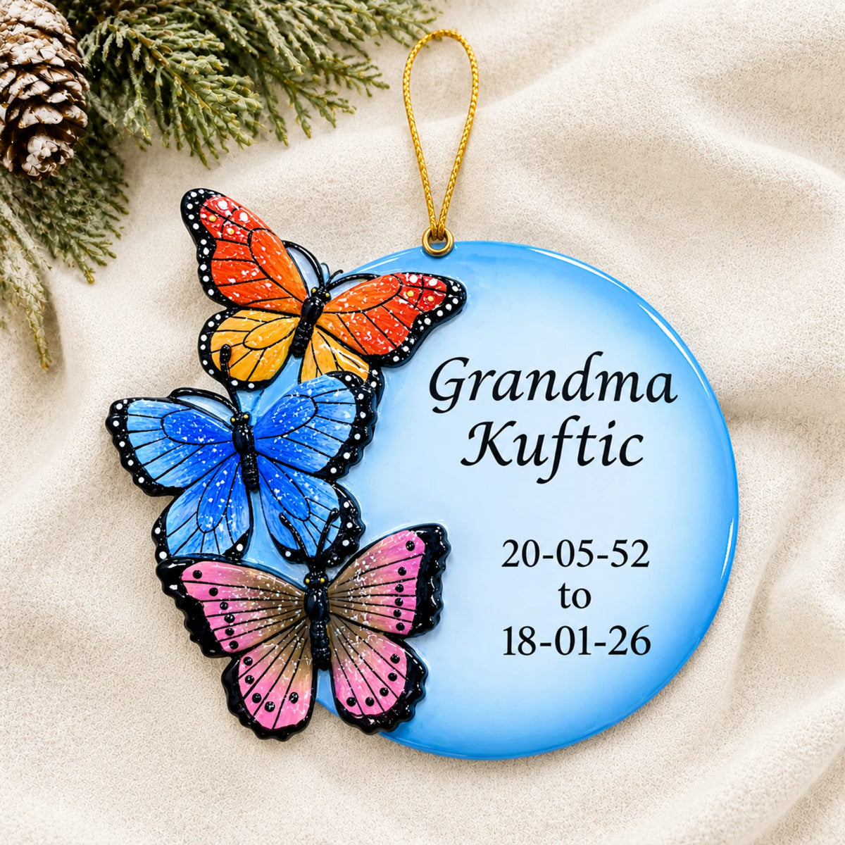 Personalized Butterfly Memorial christmas ornament laid on a soft white knit blanket
