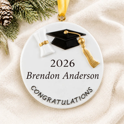 Close-up of the personalized graduation class of 2026 Christmas ornament with grad cap and gold tassel on soft knit
