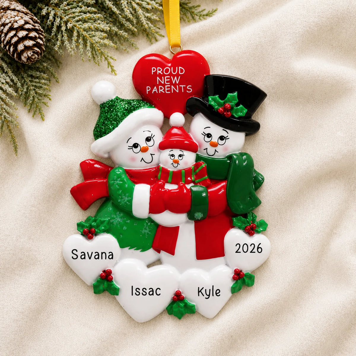Personalized new parents snowman christmas ornament laid on a soft white knit blanket