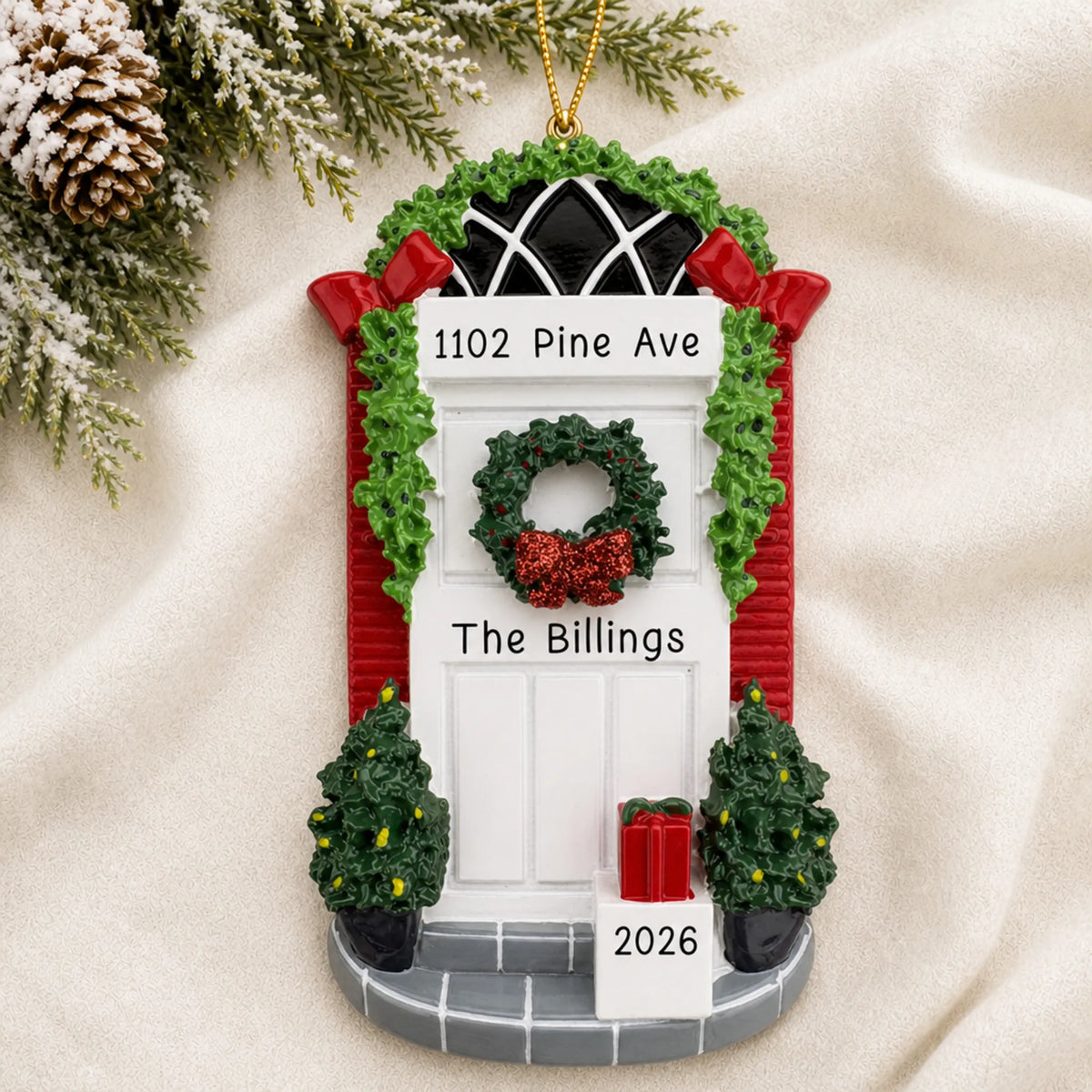 Personalized Holiday White Door christmas ornament laid on a soft white knit blanket