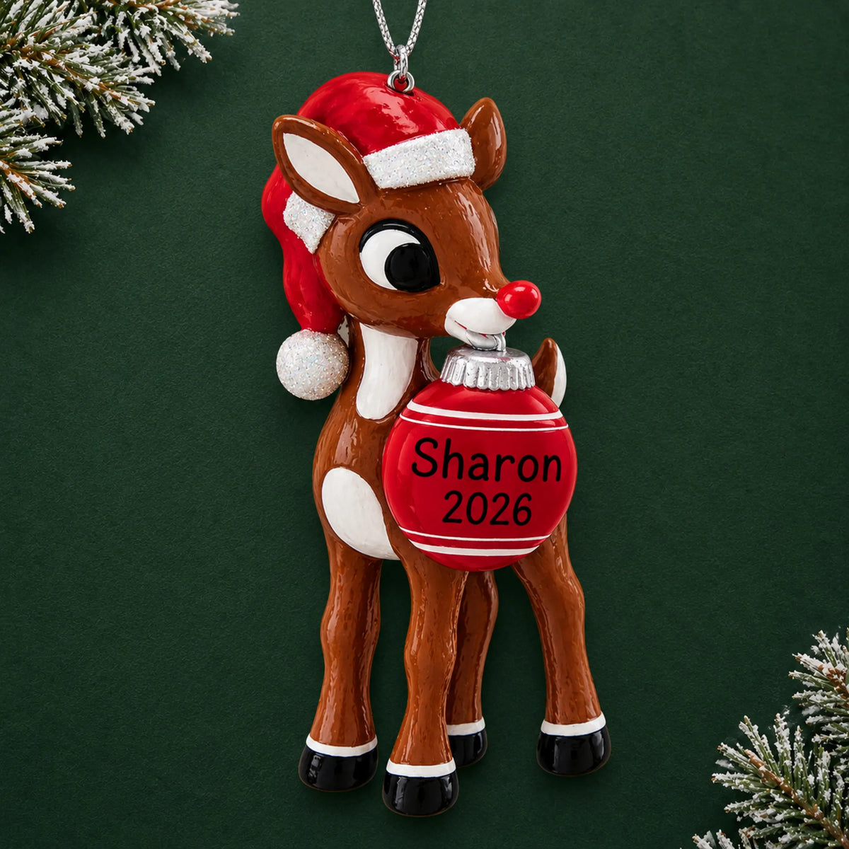 Personalized Rudolph the Red-Nosed Reindeer christmas ornament on a dark green pine background