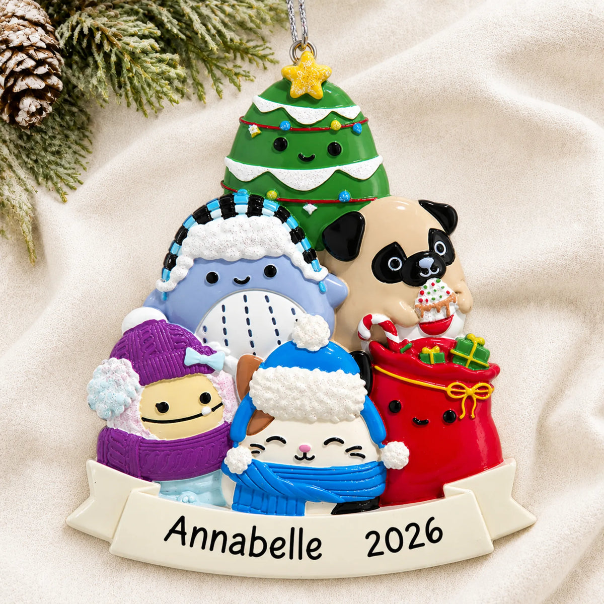 Personalized Squishmallows christmas ornament laid on a soft white knit blanket