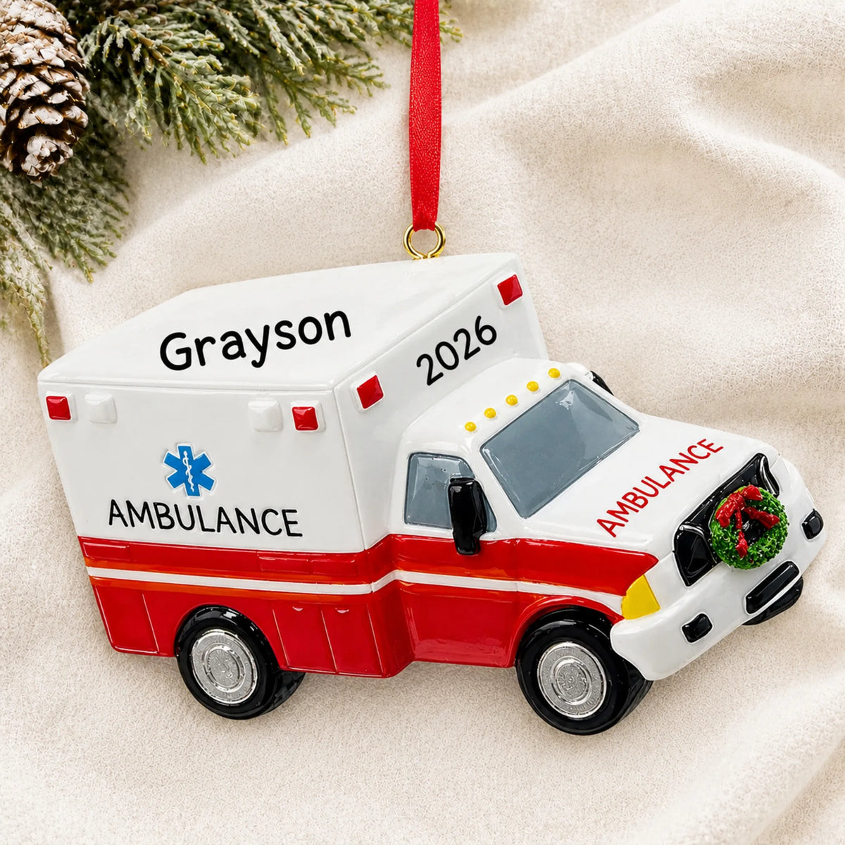 Personalized paramedic ambulance christmas ornament laid on a soft white knit blanket