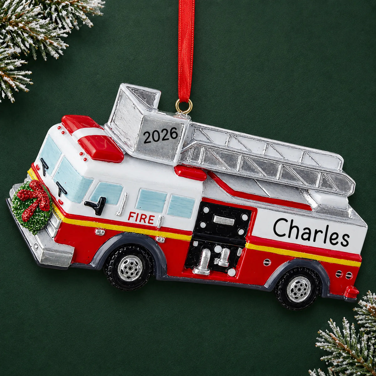 Personalized fire truck with ladder christmas ornament on a dark green pine background