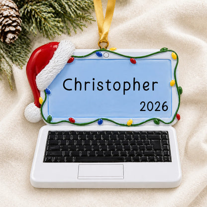 Personalized laptop computer christmas ornament laid on a soft white knit blanket