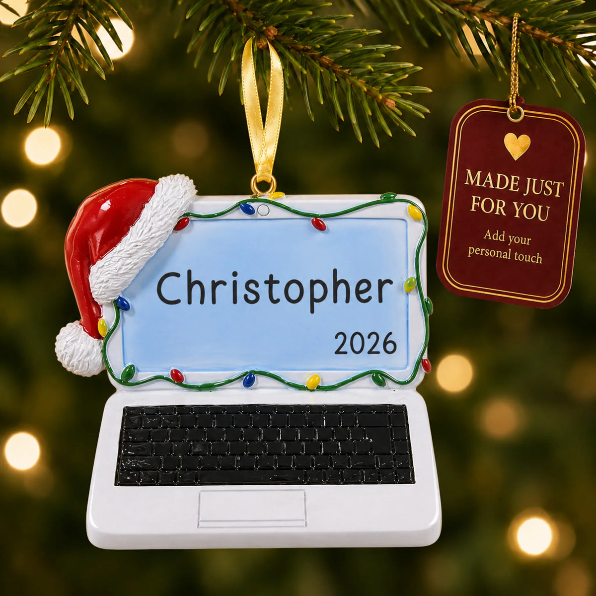 Laptop computer christmas ornament hanging on a lit Christmas tree with a Made Just For You gift tag