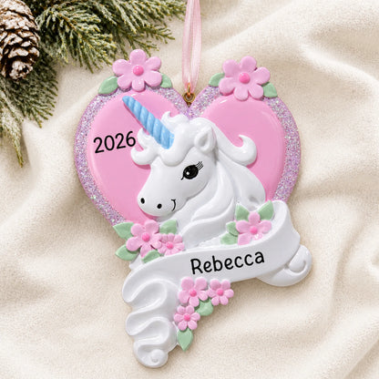 Personalized unicorn heart christmas ornament laid on a soft white knit blanket