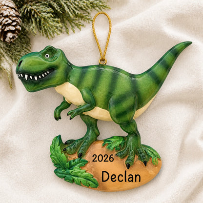 Personalized t-rex dinosaur christmas ornament laid on a soft white knit blanket