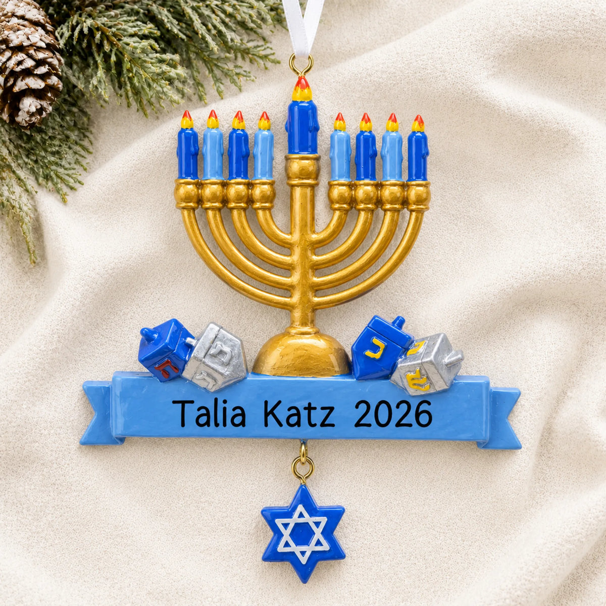 Personalized Hanukkah Menorah christmas ornament laid on a soft white knit blanket
